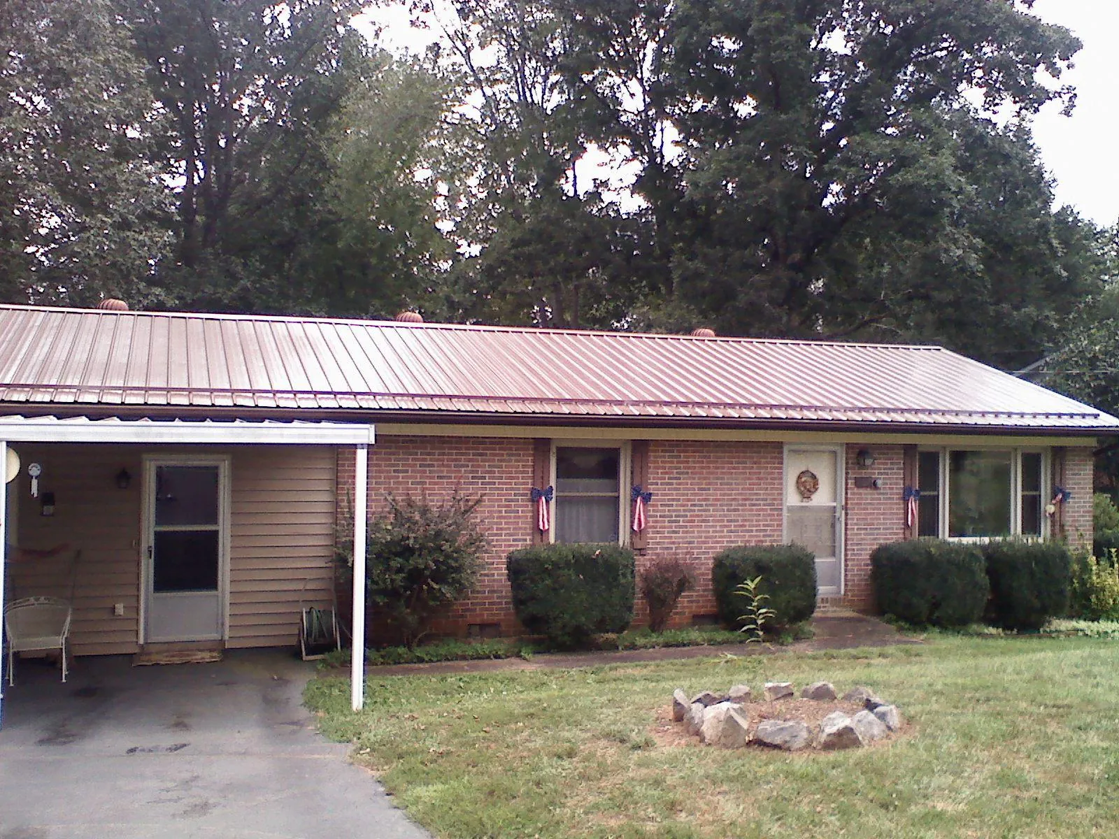 Bronze metal roof and carport on a brick ranch home — Roof Repair work by our crew in Kiowa